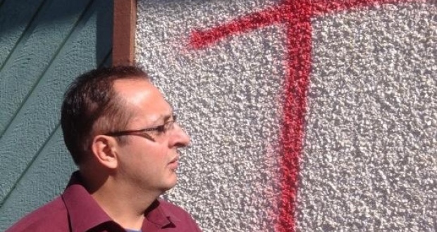 Waseem Akhtar examines the damage done to his home. Twice in one week, vandals attacked his home with spray paint and eggs marked with anti-Muslim messages. (Andrea Huncar/CBC)