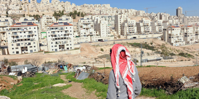 A Palestinian looks at the Israeli settlement Har Homa in the West Bank